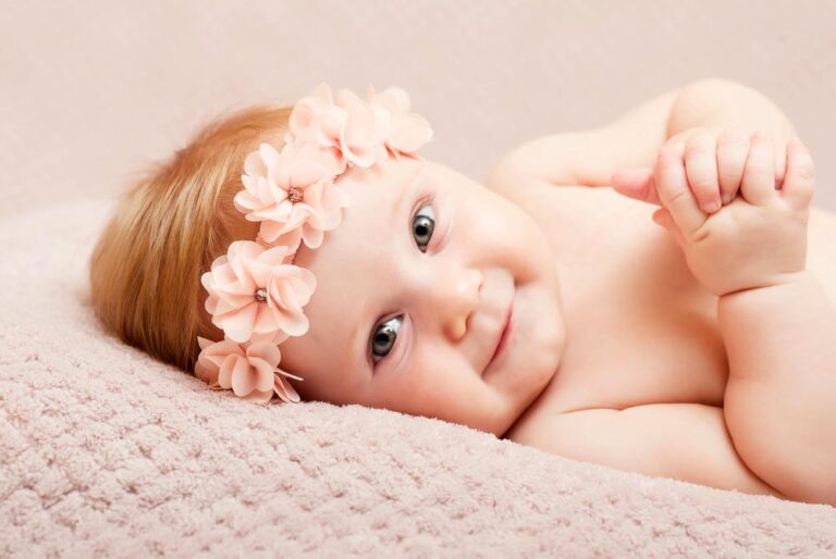 portrait of caucasian newborn with pink flower headband